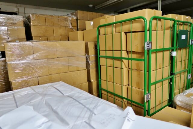 倉庫内に積まれた新品エアコンなどの余剰在庫